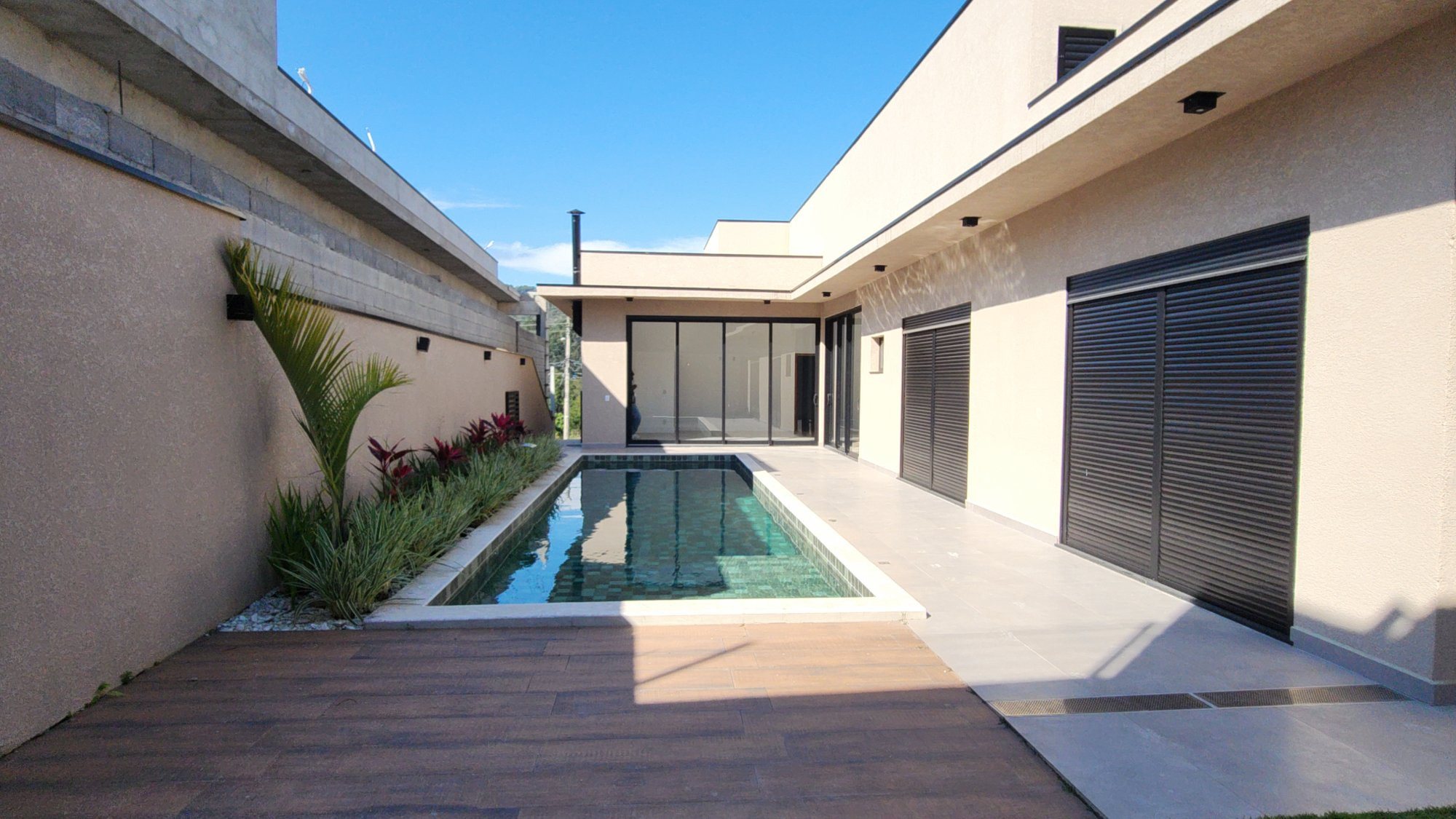 Pátio com piscina revestida em pastilha verde