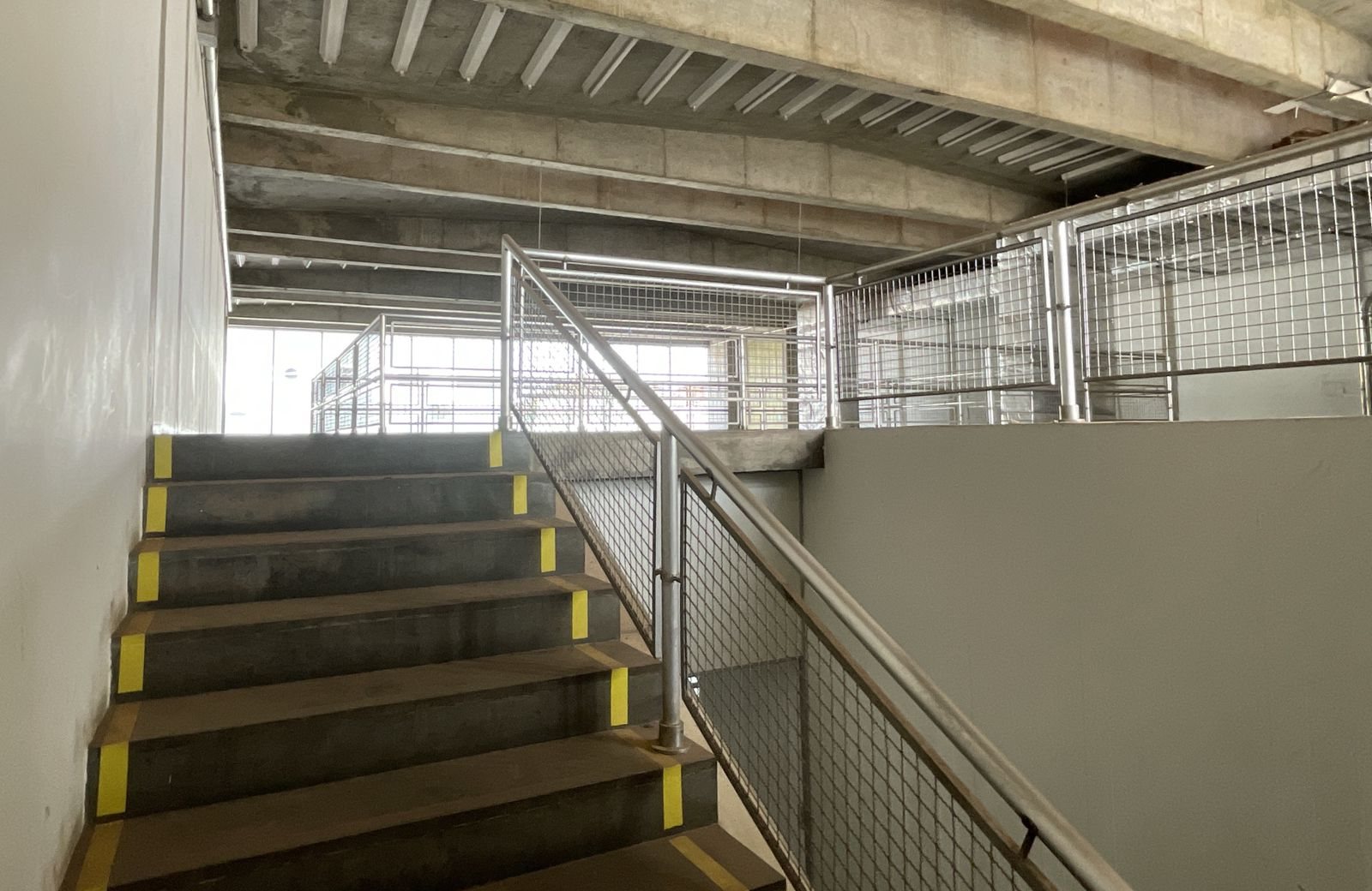 Escada em concreto com fitas antiderrapantes nos bocéis